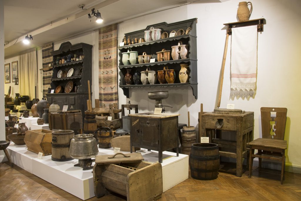 Wnętrze Muzeum w Mrągowie z historycznym biurkiem, fotografiami i pamiątkami regionalnymi